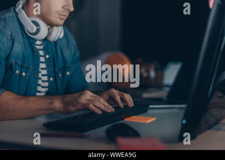 cropped view of young programmer working near african american colleague sleeping at workplace Stock Photo