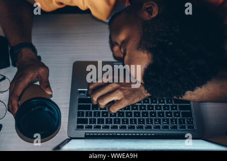 exhausted african american programmer sleeping on keyboard Stock Photo