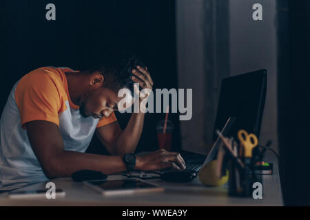 sleepy african american programmer sitting at workplace with closed eyes Stock Photo