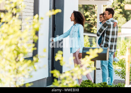 selective focus of african american family walking into new house while father holding kid Stock Photo