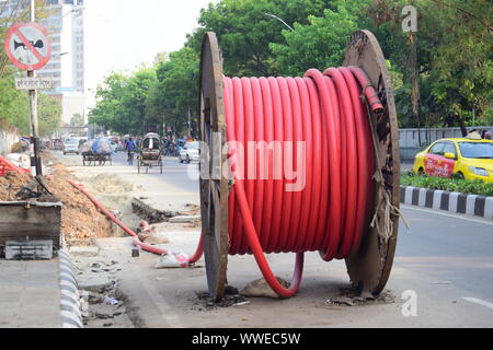Big bobbin of electric wire on a road construction site Stock Photo