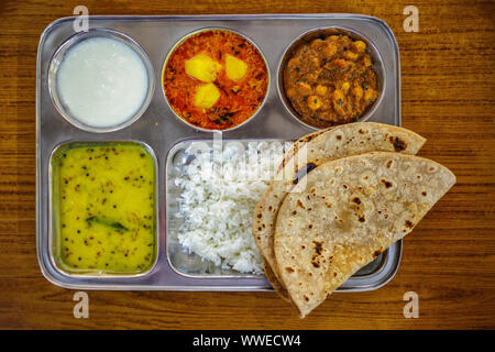 Thali - Traditional Indian Food. Steel tray with multiple compartments for rice, dal, vegetables, roti, papad, dahi, small amounts of chutney or pickl Stock Photo