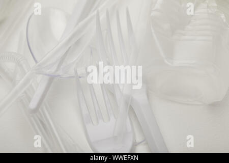 close up view of crumpled plastic cup, forks and spoons on white background Stock Photo