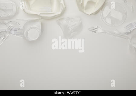 top view of crumpled plastic cups, plates, forks and spoons on white background with copy space Stock Photo