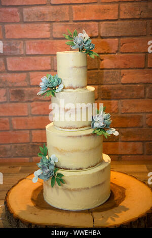 Four tiered wedding cake, with cream buttercream icing and succulents decorating the cake, wedding cake Stock Photo