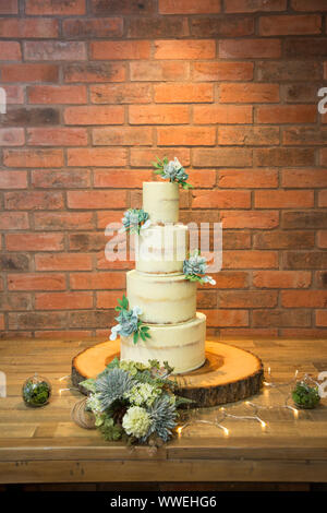 Four tiered wedding cake, with cream buttercream icing and succulents decorating the cake, wedding cake Stock Photo