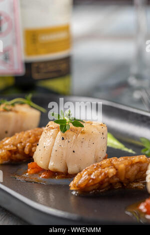 Grilled tasty scallops served on black plate Stock Photo