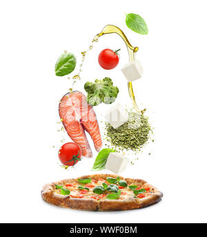 Tasty pizza with falling ingredients on white background Stock Photo