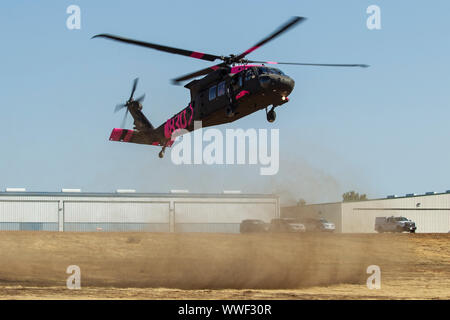 A U.S. Army UH-60 Black Hawk helicopter flown by the California Army National Guard's Army Aviation Support Facility #1 in Los Alamitos lands at a helibase to drop off and pick up firefighters, Sept. 12, 2019, in Red Bluff, California, while supporting efforts to contain the South Fire burning in Tehama County. Six Cal Guard helicopters were activated to assist state and federal agencies battling a pair of wildfires in the county. (U.S. Air National Guard photo by Staff Sgt. Crystal Housman) Stock Photo