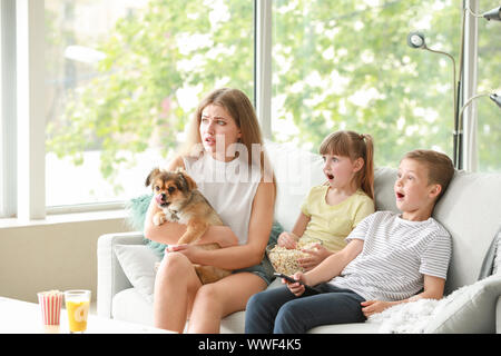 Family watching scary movie at home Stock Photo