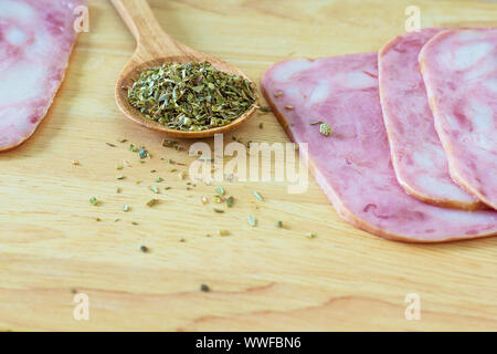 Fresh roast ham and oregano herb on wood table Stock Photo