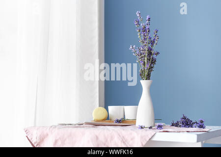 Beautiful lavender flowers in vase on table in room Stock Photo