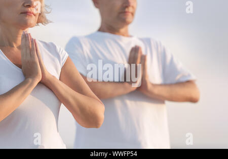 Mature couple practicing yoga at sea resort Stock Photo
