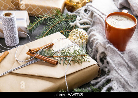 Beautiful Christmas gift box with cup of coffee on table Stock Photo