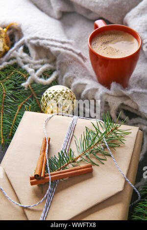 Beautiful Christmas gift box with cup of coffee on table Stock Photo