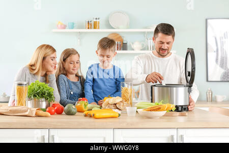 Happy family using modern multi cooker in kitchen Stock Photo