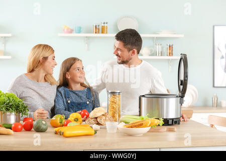 Happy family with modern multi cooker in kitchen Stock Photo