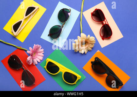 Stylish sunglasses with flowers on color background Stock Photo