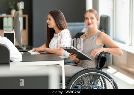 Handicapped young woman with colleagues working in office Stock Photo