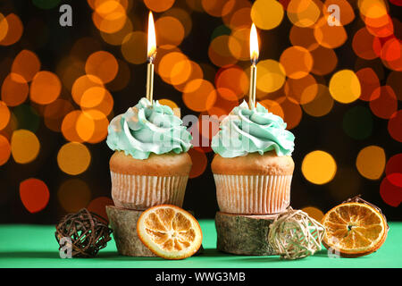 Tasty Birthday cupcakes on table against defocused lights Stock Photo
