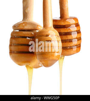 Wooden honey dippers on white background Stock Photo