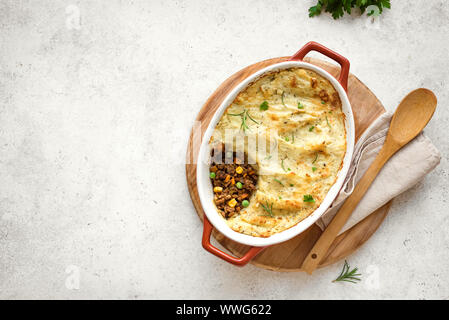 Shepherd's Pie with ground beef, potato and cheese on white background, top view, copy space. Traditional homemade casserole - Shepherds Pie. Stock Photo