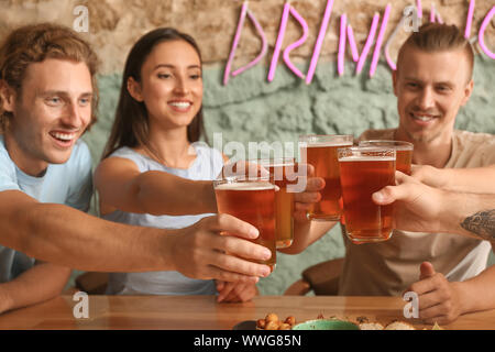 Friends drinking fresh beer in pub Stock Photo