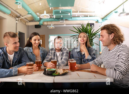Friends drinking fresh beer in pub Stock Photo