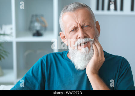 Senior man suffering from toothache at home Stock Photo