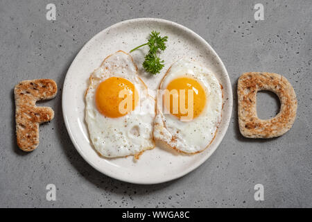 Word food written with toast letters fried eggs Stock Photo