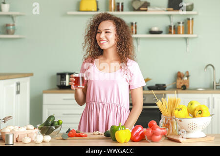Beautiful African-American woman cooking in kitchen Stock Photo