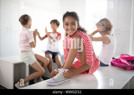 Cheerful dark-skinned girl feeling happy after PE class Stock Photo