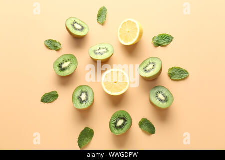 Composition with tasty cut kiwi and lemon on color background Stock Photo