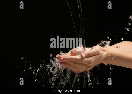 Woman washing hands on dark background Stock Photo