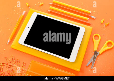 Modern tablet computer and stationery on color background Stock Photo