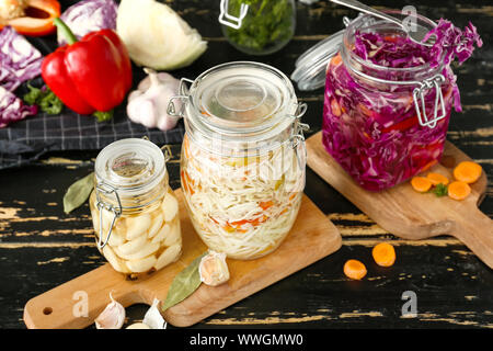 Jars with different canned vegetables on table Stock Photo