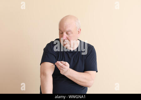 Diabetic man giving himself insulin injection on light background Stock Photo