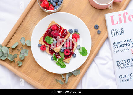Plate with toasted bread, tasty jam and berries on tray Stock Photo