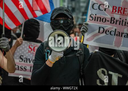 Hong Kong. 15th Sep, 2019. A protester speaks on megaphone during a pro-democracy march. Protesters continue to demonstrate across Hong Kong for the 15th consecutive week. After marching for few hours from Causeway Bay towards Admiralty, clashes between protesters and riot police occurred in different parts of the island. Chief Executive Carrie Lam withdraw the polemic extradition law and protesters now call to the government to attend the rest of their demands, including an independent inquiry into police brutality, the retraction of the word 'riot' to describe the rallies, and genuine univer Stock Photo