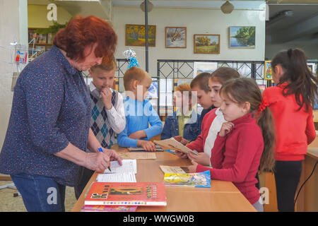 Chapaevsk, Samara region, Russia - May 10, 2019: Elementary school. Woman Teacher with primary school students. School children are standing next to t Stock Photo