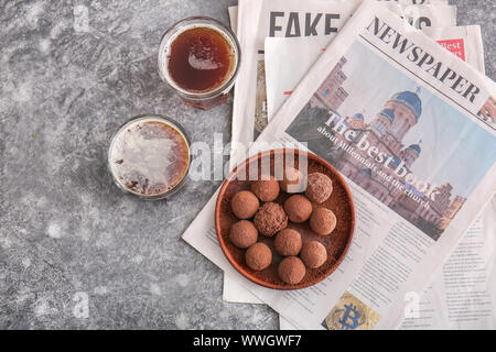 Plate with tasty sweet truffles and drink on grey background Stock Photo