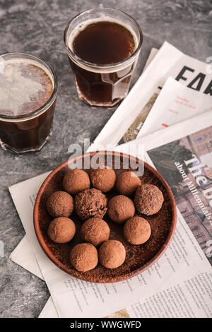 Plate with tasty sweet truffles and drink on grey background Stock Photo
