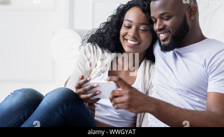 Young couple browsing social media on smartphone at home Stock Photo