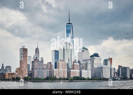 Manhattan skyline with stormy sky seen from the river, color toning applied, NYC. Stock Photo