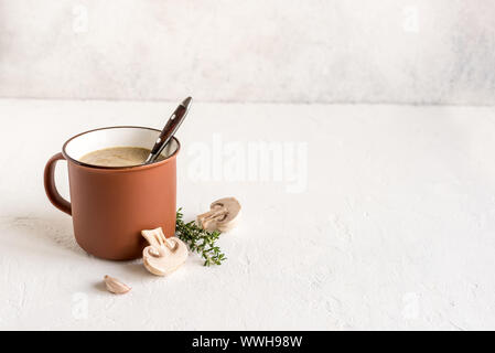 Mushroom Soup. Homemade champignons cream soup in enamel mug. Healthy and comfort food concept, copy space. Stock Photo