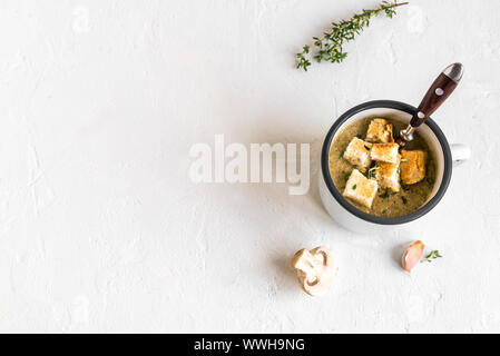 Mushroom Soup. Homemade champignons cream soup with croutons in enamel mug. Healthy and comfort food concept, copy space. Stock Photo