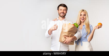 Spouses Holding Paper Grocery Bag Pointing Finger At Camera, Panorama Stock Photo
