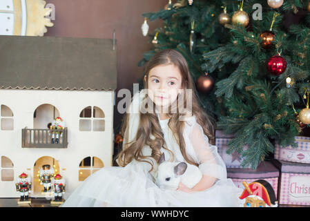 Little girl and white chinchilla nut. Happy Chinese New Year 2020 year of rat. symbol of new year. ballerina with nutcracker in studio Stock Photo