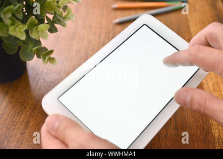 Hands using white tablet with white screen on desk close up. Horizontal composition. Elevated view Stock Photo