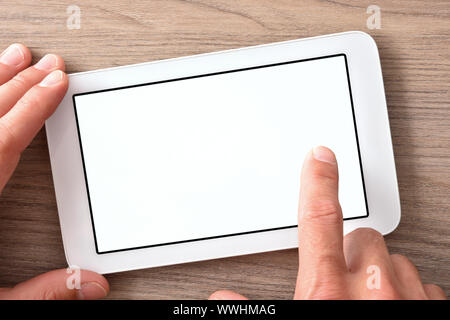 Hands using white tablet with white screen on wood table close up. Horizontal composition. Top view Stock Photo